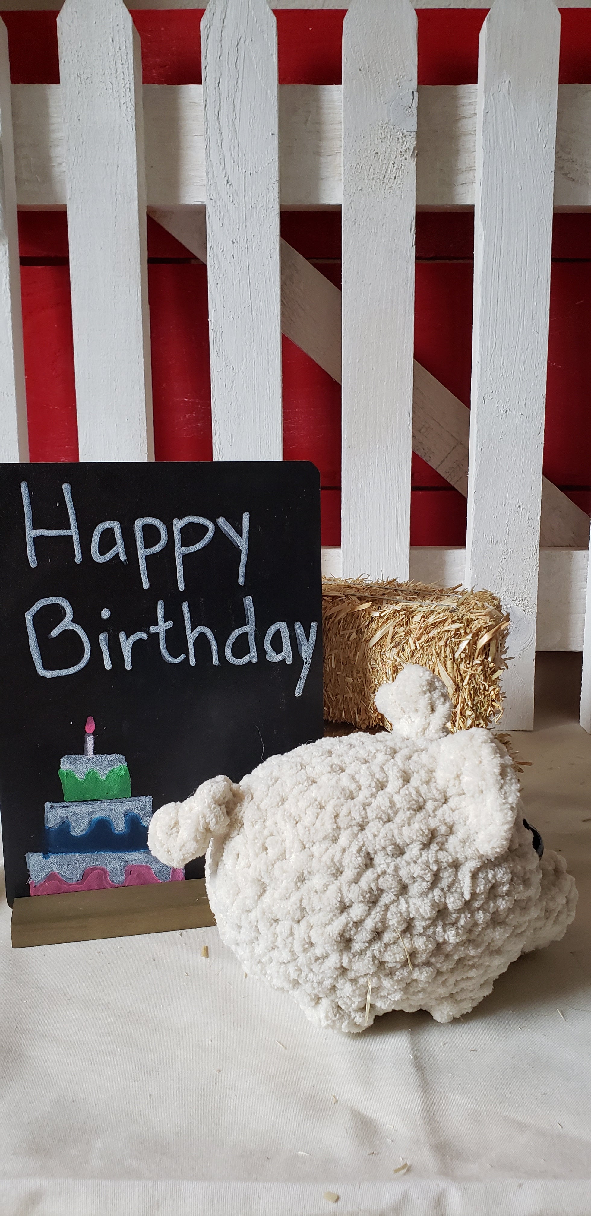 Almond crocheted mini pig plushie side profile with Happy Birthday sign