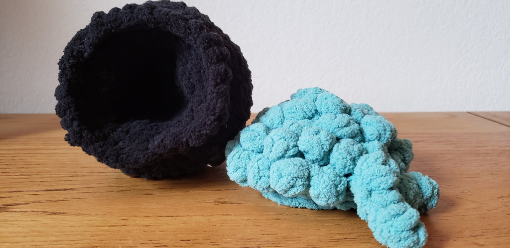 Mini crochet cauldron with removable lid shown open, turquoise bubbling liquid piece beside black cauldron body