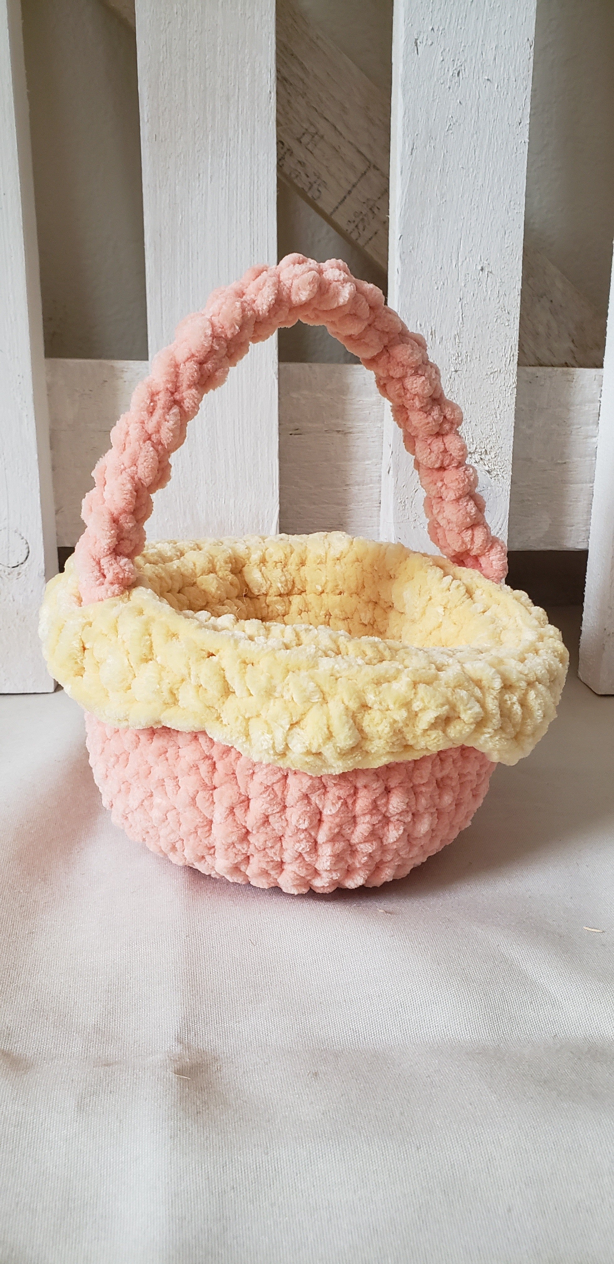 Small peach crochet Easter basket with yellow lining front view showing handle and basket shape
