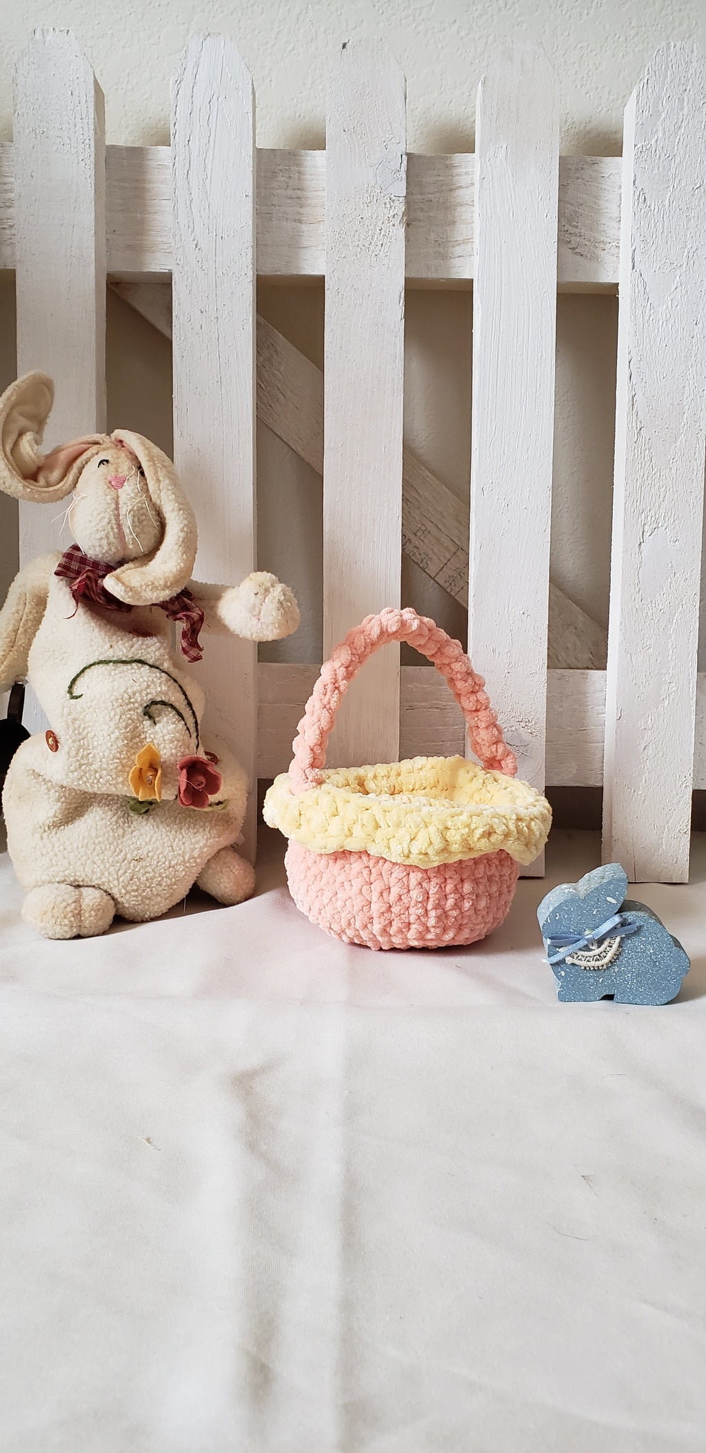 Small peach crochet Easter basket with yellow lining displayed with Easter bunny figurine - glamour shot