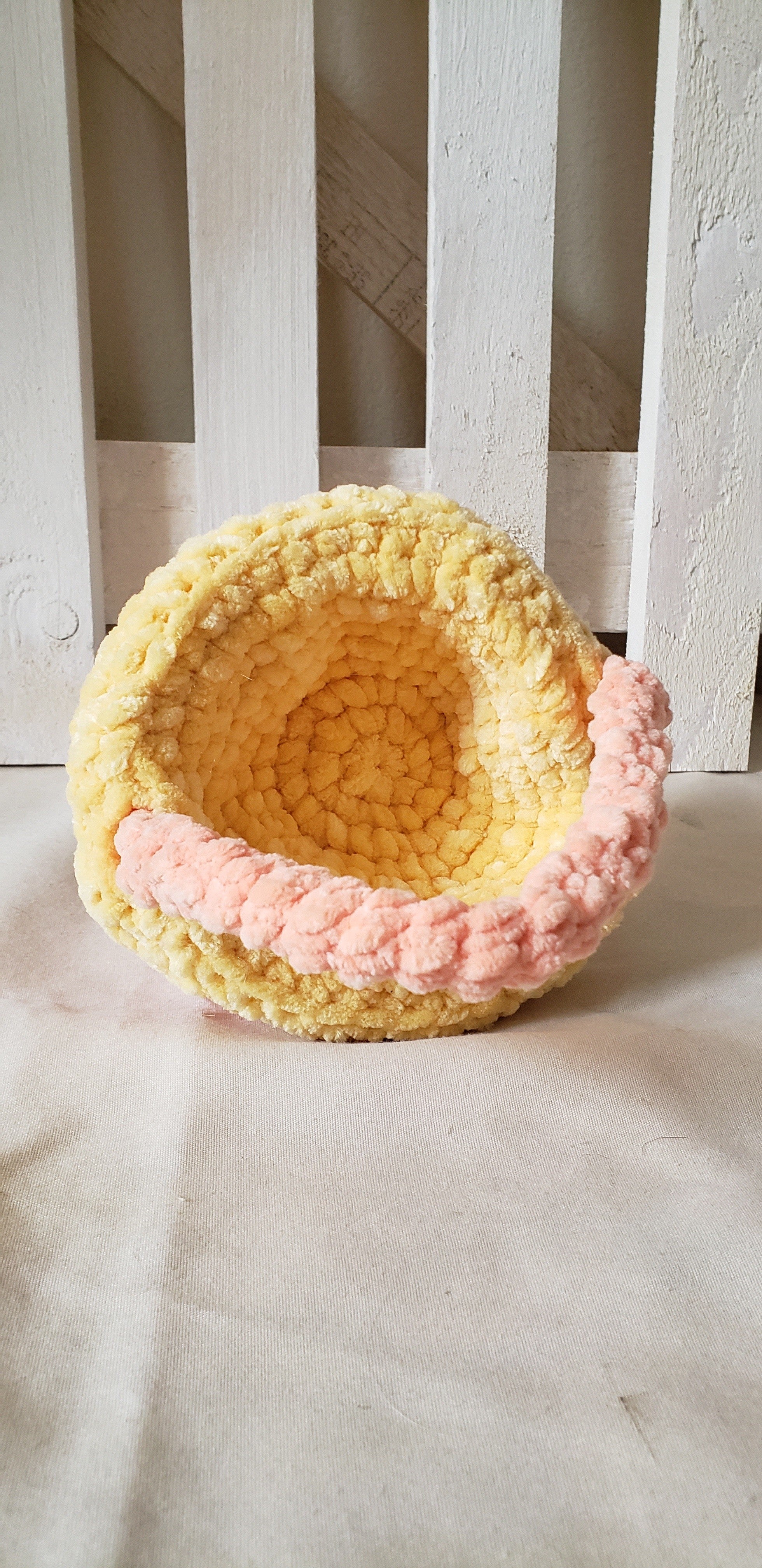Small peach crochet Easter basket tipped on side showing yellow interior lining detail