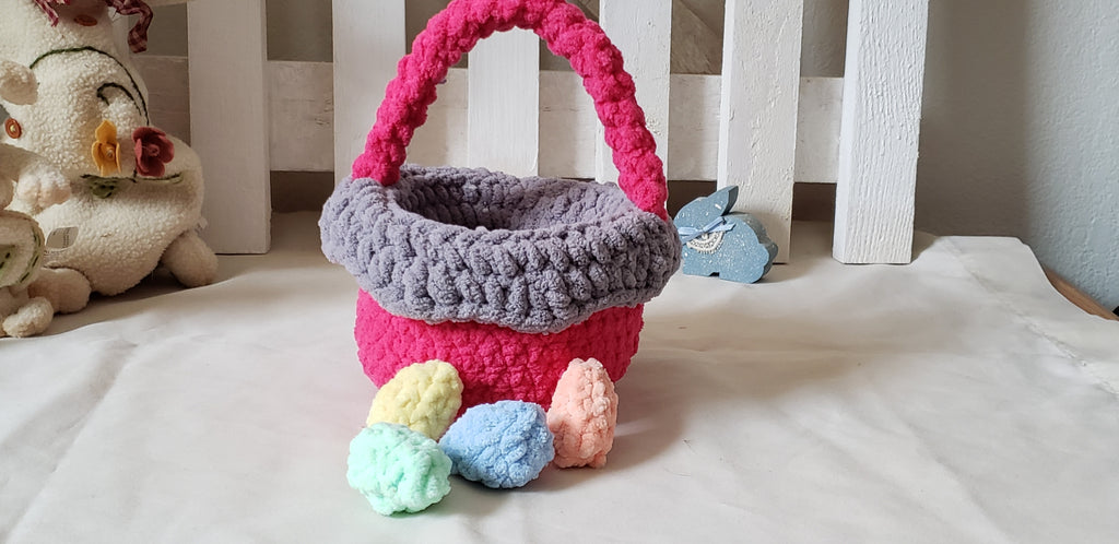 Hot pink crochet Easter basket with pastel eggs displayed with Easter bunny figurines - glamour shot
