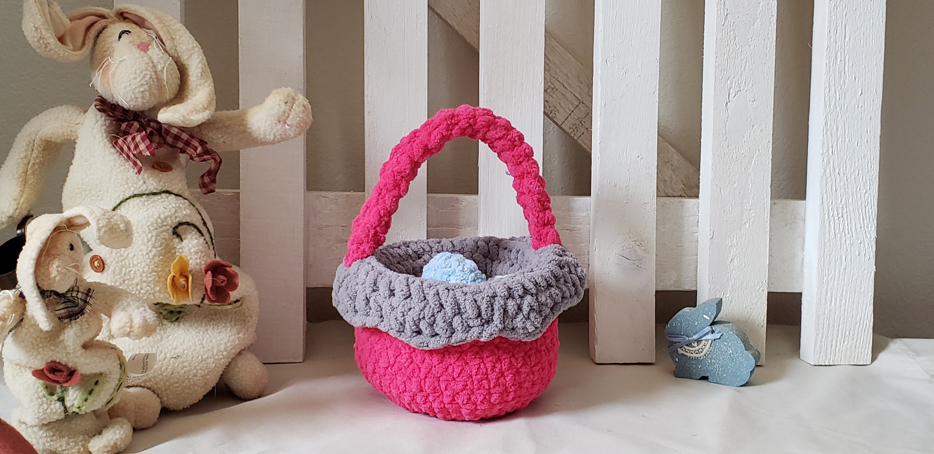 Hot pink crochet Easter basket with grey lining and 4 pastel plush eggs in front - glamour shot