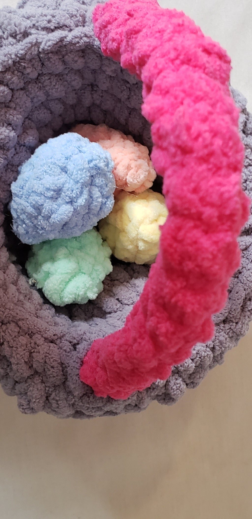 Hot pink crochet Easter basket inside view with pastel plush eggs inside