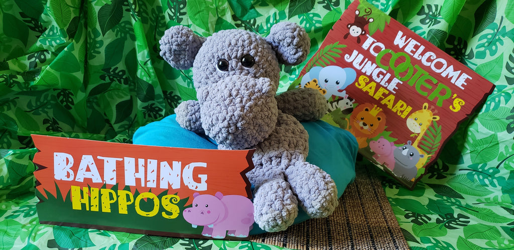 Crocheted gray hippo snuggler with Cooter's Jungle Safari and Bathing Hippos signs