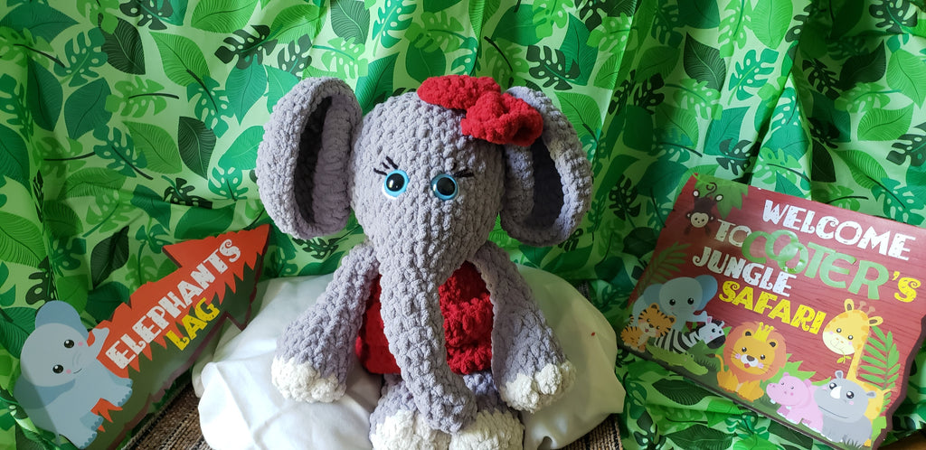 Crocheted elephant plushie front view with red dress and bow
