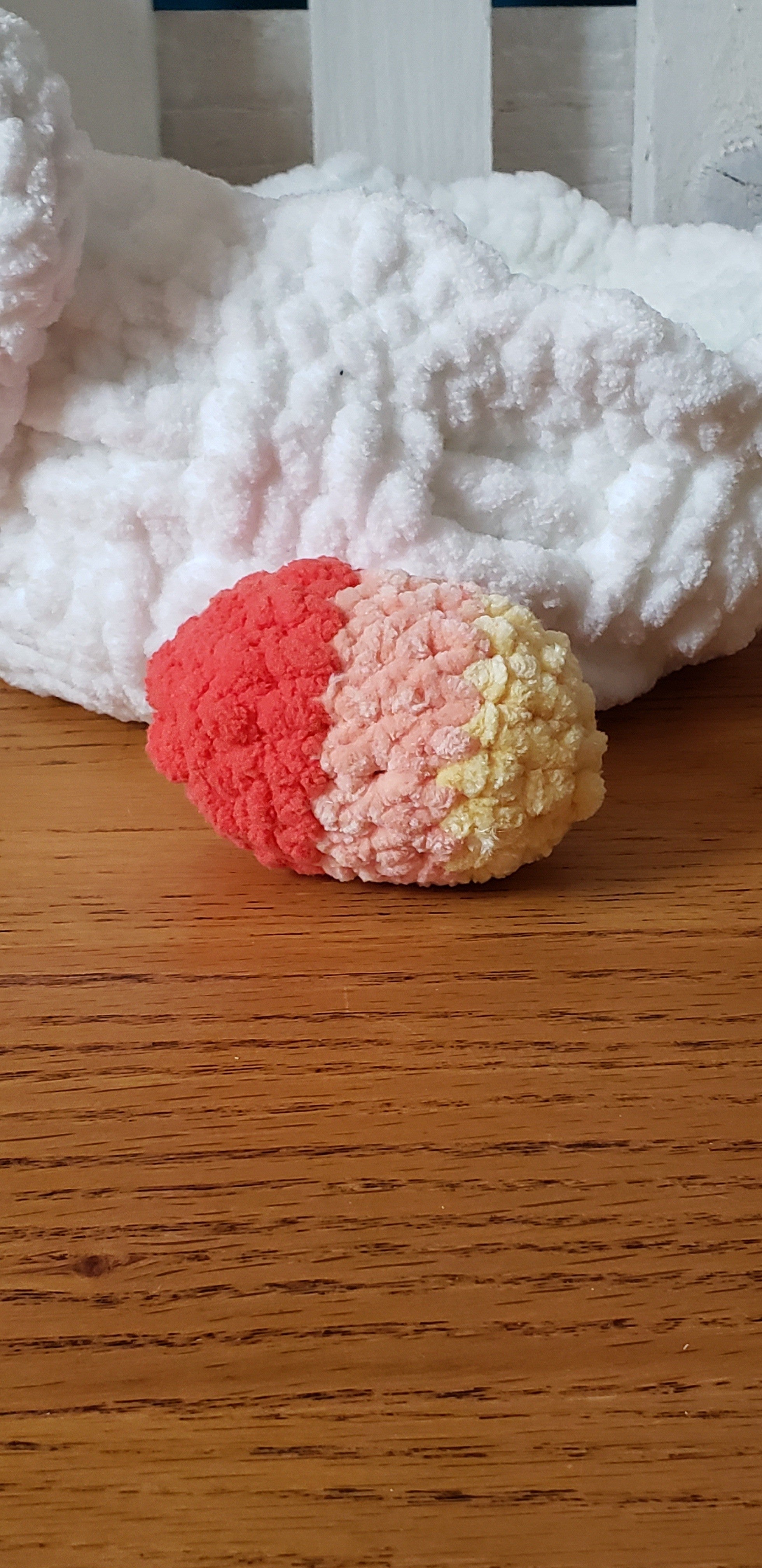 Peach, coral and yellow three-tone crochet Easter egg close-up