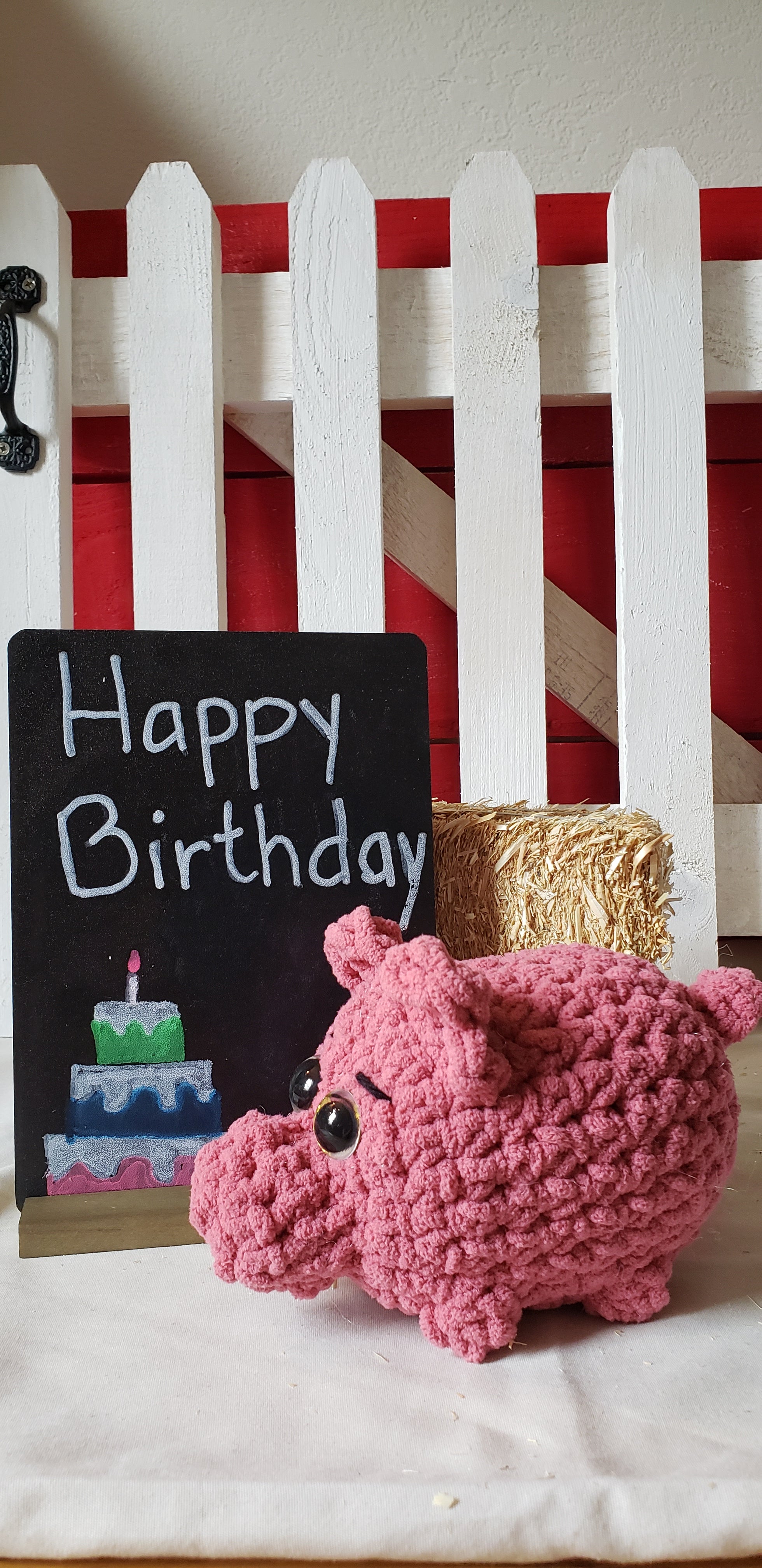 Pink crocheted mini pig plushie with Happy Birthday chalkboard sign