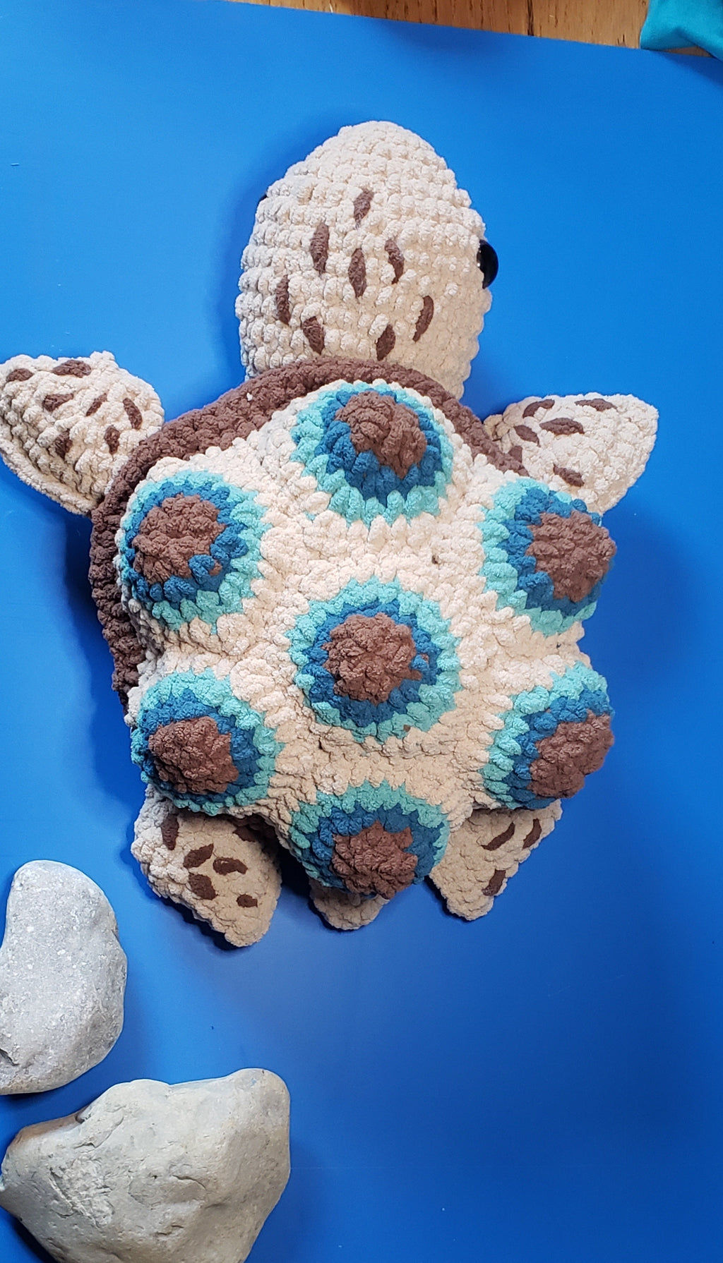 Crochet turtle plushie top view showing blue and brown patterned shell